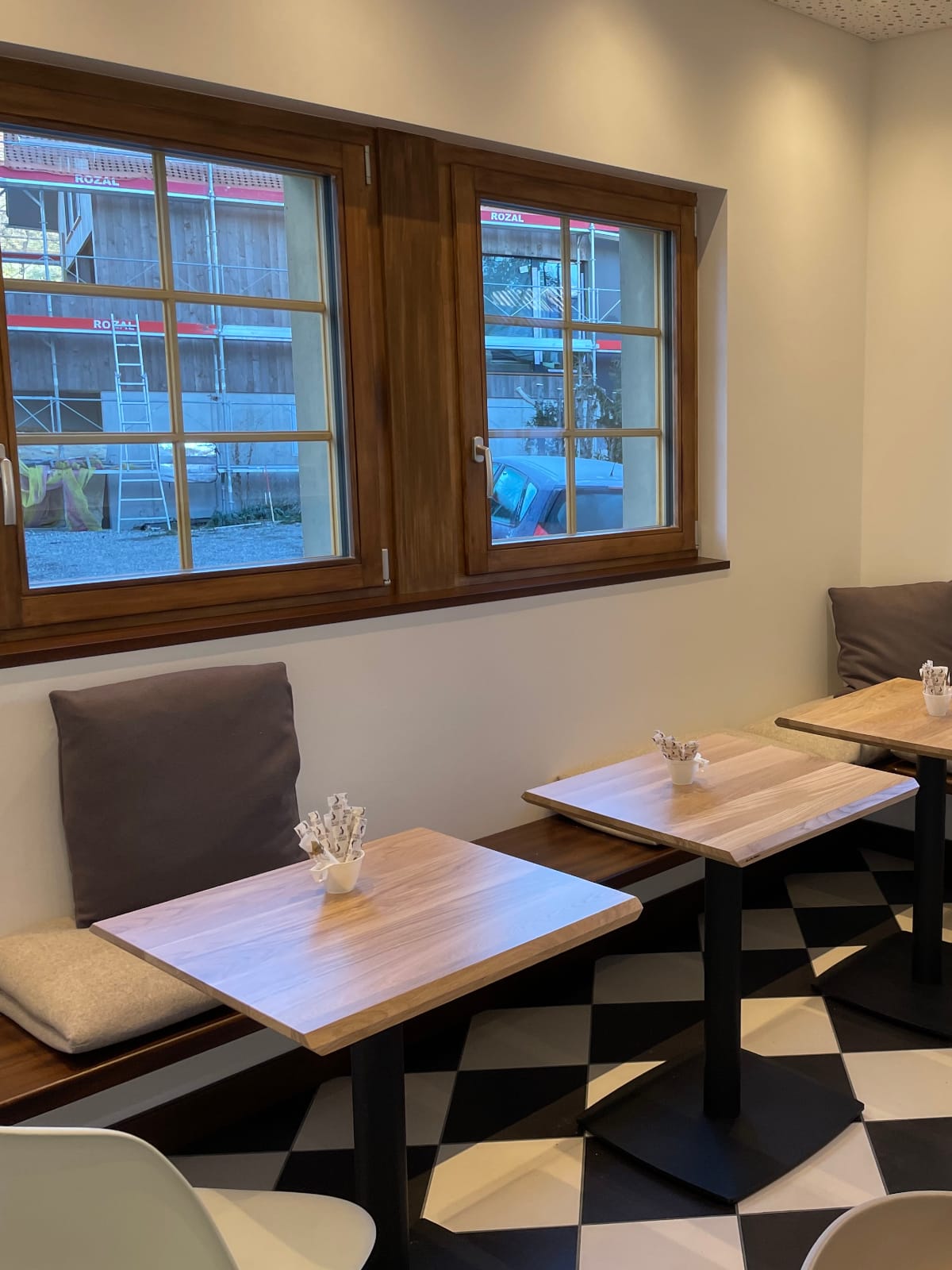 Intérieur de café moderne avec fenêtre et sièges.